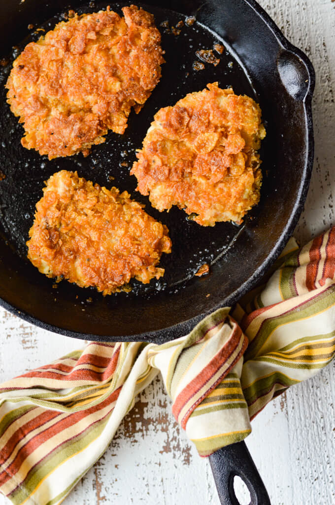 Three crispy cooked chicken in cast iron skillet
