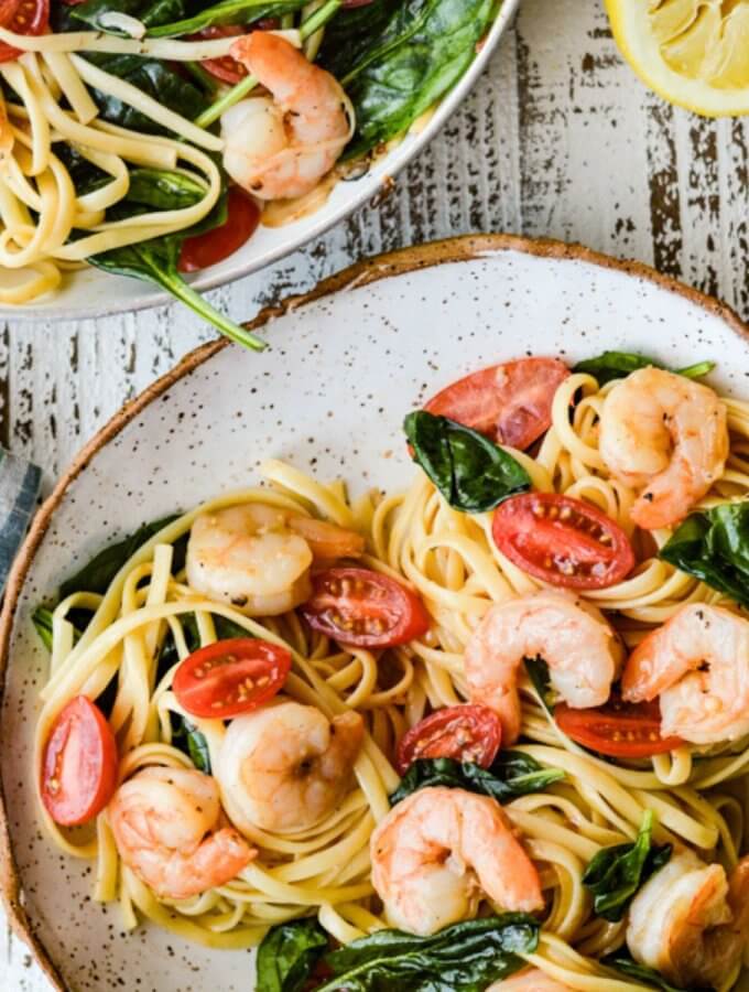 A plate of shrimp scampi with pasta.